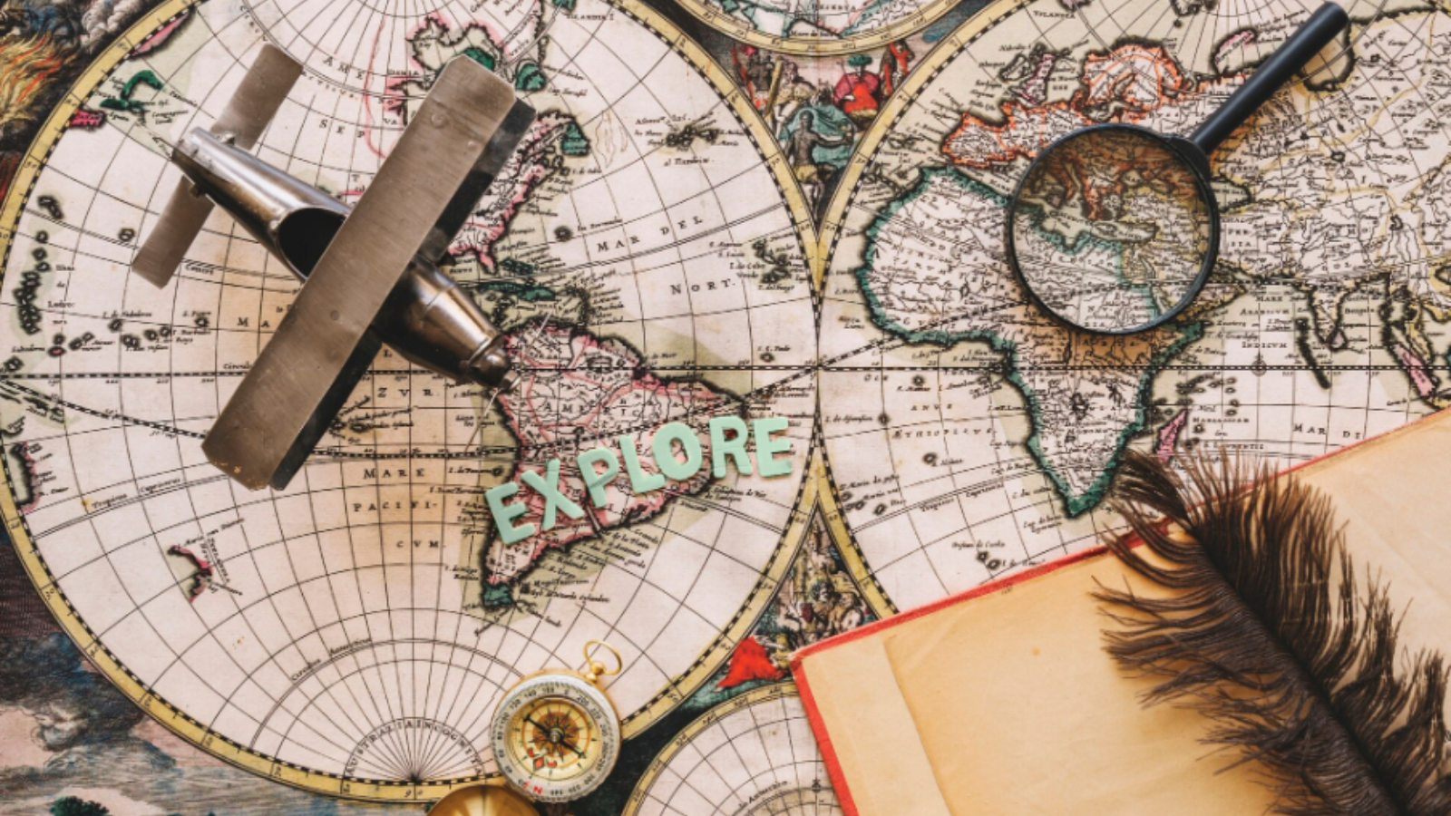 A vintage map with a magnifying glass, toy airplane, compass, and feather quill. The word "EXPLORE" suggests adventure and discovery.